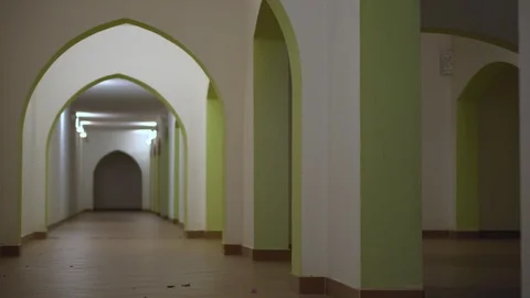 Long corridor in the building with arches. Evening time with artificial lighting Видео 100649039