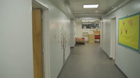 A long corridor with doors and Windows in the building . Video stock 136447314