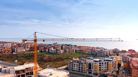 Long crane boom over the large building construction. Video stock 325041084