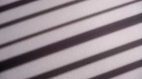 Long dark sunlit shadows from a hanging blind swaying slowly on tiled floor Stock Footage 173481241
