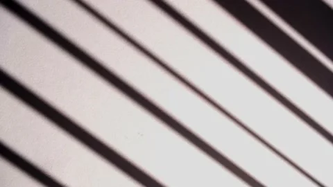 Long dark sunlit shadows from a hanging blind swaying slowly on tiled floor Stock Footage 173482203