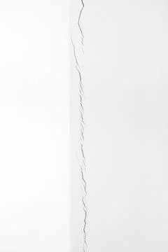 Long, deep crack in the white wall. Construction problems. Shrinkage of the h Stock Photos