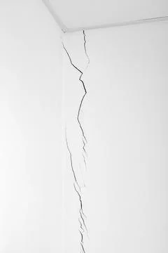 Long, deep crack in the white wall. Construction problems. Shrinkage of the.. Stock Photos