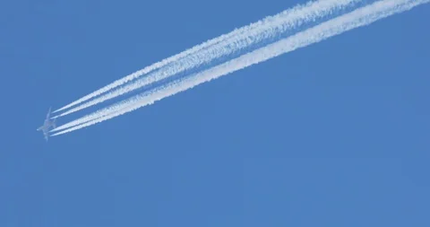 A long diagonal trail of jet plane on blue sky - passenger airliner Video stock 105436797