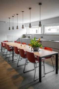 long dining table with red chairs in an office building.