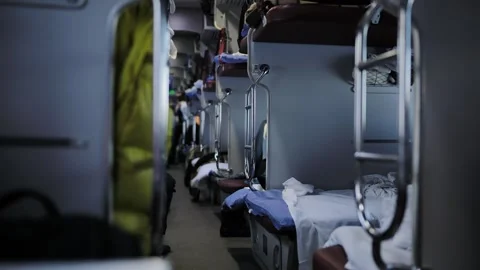 Long distance sleeper train corridor with multiple bunk beds and travel luggage Stock Footage 344698276