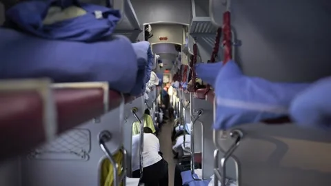Long-distance train compartment with bunk beds and passengers traveling Stock Footage 344697245