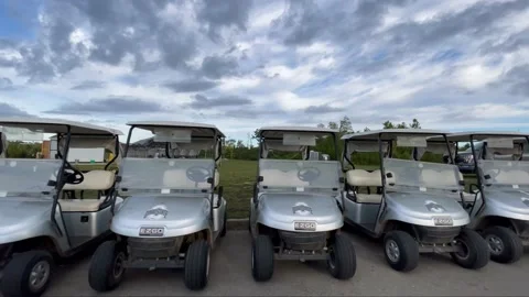Long dolly shot of multiple golf carts in a row Stock Footage 239042858