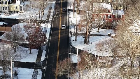 Long Drone Follow Shot Behind Snow Covered White Sedan in Suburban Massachusetts Stock Footage 296074958