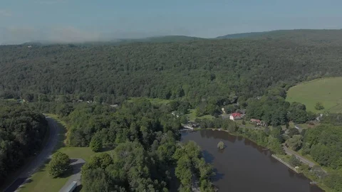 Long drone shot over a tiny town and river in a valley in the Catskill Stock Footage 97869343