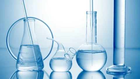 Long dropper is lowered into flask surrounded by lab glassware Stock Footage 167168534