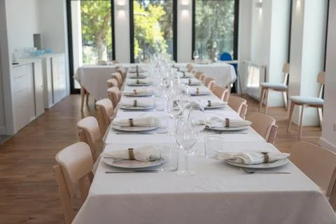 Long elegantly set party table in a bright room Stock Photos