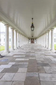 Long empty colonnade with white pillars and stone floor Fotos Stock