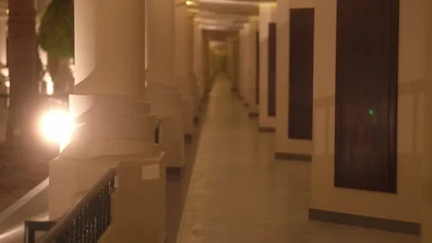 A long empty corridor of the hotel in the evening with warm lighting Stock Footage 296072786