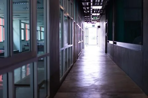 A long empty corridor inside the office entrance hall after work hours Stock Photos