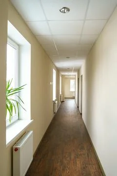 A long empty corridor in an office building. A new modern heating radiator on Foto stock