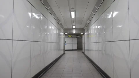 A long, empty hallway with white walls and grey flooring Video stock 297859664