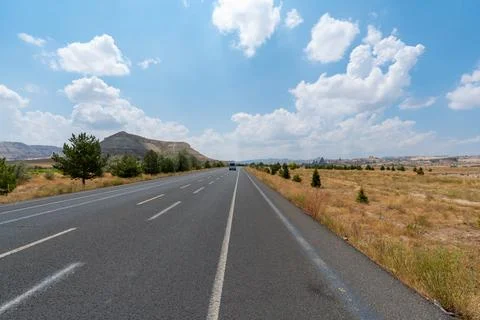Long empty highway stretching into the distance under a clear blue sky Stock Photos
