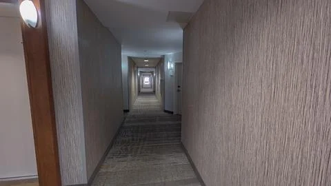 Long empty hotel corridor with patterned carpet walls and doors Stock Photos
