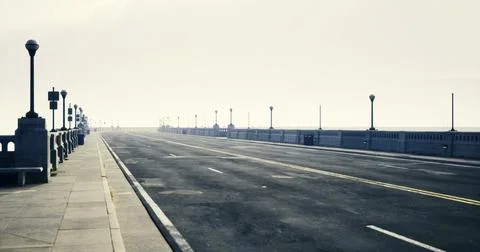 Long empty road leading to the horizon in a foggy coastal setting Stock Illustration