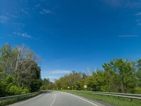 A long empty road in the middle of a forested area Stock Photos