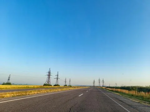 A long empty road with power lines in the distance Stock Photos