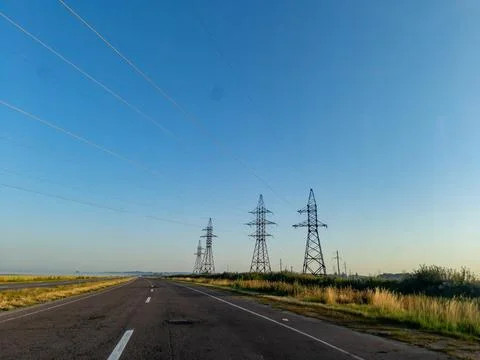 A long empty road with power lines in the distance 스톡 사진