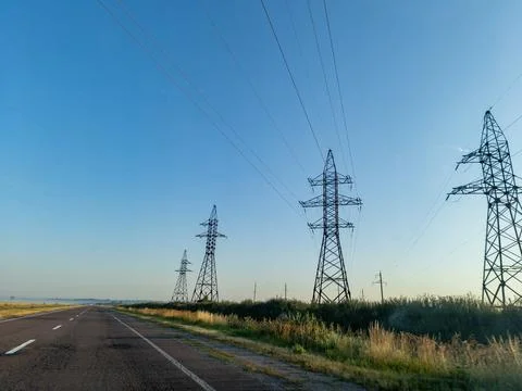 A long empty road with power lines in the distance Stock Photos