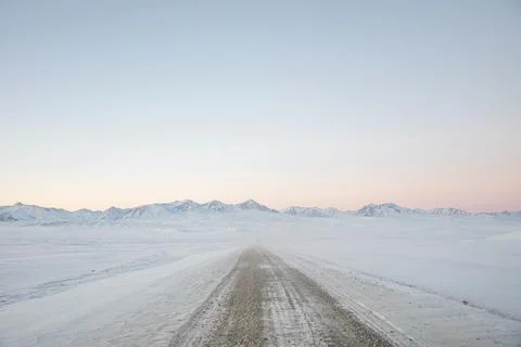 Long empty road through a vast snowy landscape Stock Photos