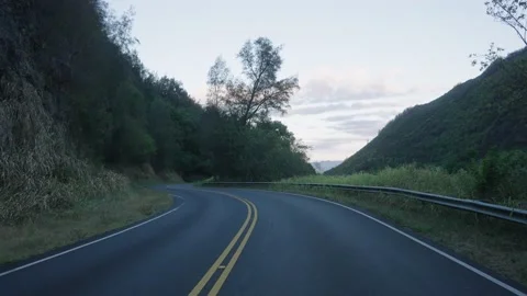 Long empty roadway surrounded by lush green mountain Stock Footage 141800510