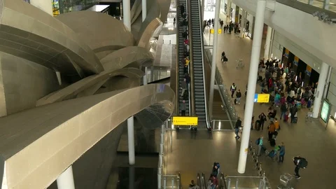 Long escalator high angle view pan of arrival level people getting into lift 動画素材 120332050