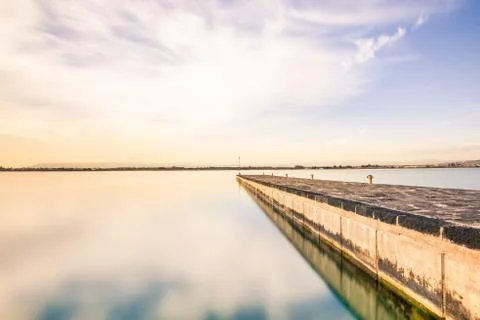 Long exposure of a bridge at evening before sunset. Blue sky, white clouds, s Foto stock