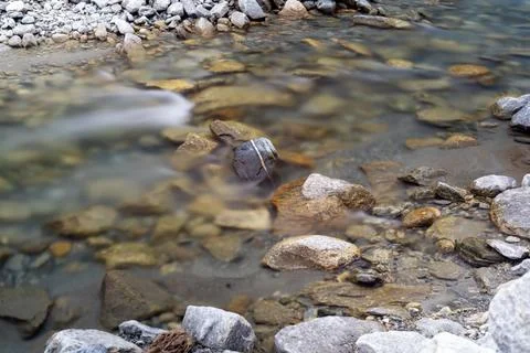 Long Exposure of a Clear Mountain Stream with Rocks and Pebbles Stock Photos