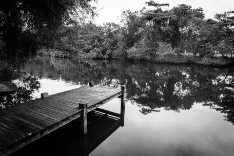 Long exposure of deck in lake, cloudy skies, black and white Stock Photos
