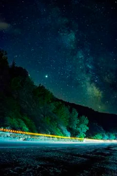 Long exposure fast moving light trails on highway,with milky way and stars Stock Photos
