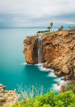 Long exposure image of the waterfall falling from the cliffs into the sea i.. Stock Photos