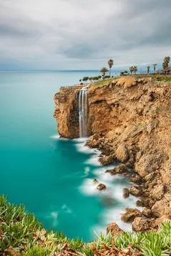 Long exposure image of the waterfall falling from the cliffs into the sea i.. Stock Photos