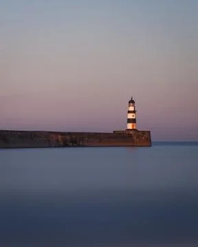 Long Exposure of a Lighthouse During Dusk during High Tide Stock Photos