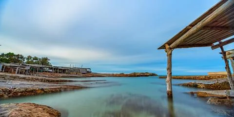 Long Exposure of Old Dock with Rails Leading to Clear Sea Stock Photos