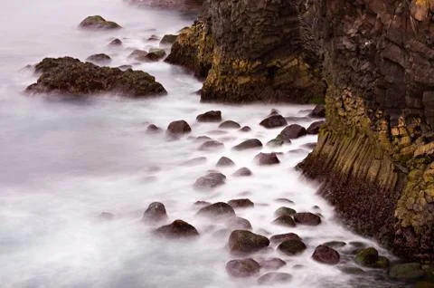 Long exposure shot of basalt columns and boulders in the surf, Iceland. Stock Photos