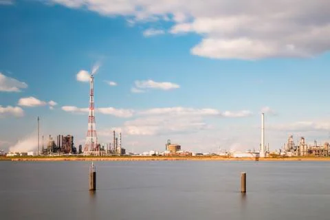 Long exposure shot of a refinery with tall flare stack in the port of Antwerp Stock Photos