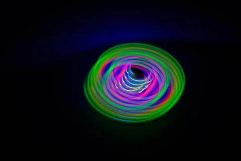 Long exposure, slow shutter, multicolor Led light painting of a spinning top Stock Photos