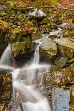 Long exposure of a small water course in Transylvania forests, Romania early Stock Photos