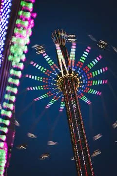 Long exposure of a spinning chain carousel at night Stock Photos