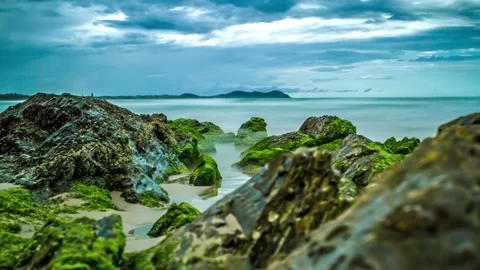 Long Exposure Timelapse Moody Sky Behind Mossy Beach Rocks and Waves - Byron Bay Stock Footage 138670895