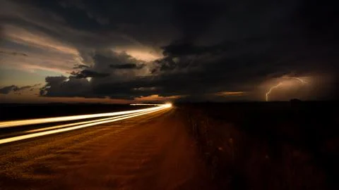 Long Exposure Vehicle Lights With Storm Clouds and Lightning in Background Stock Photos
