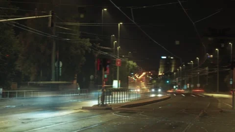 A long-exposure view of a nighttime city street, with the blur of a tram Stock Footage 286312971