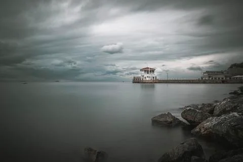 Long Exposure villa with dramatic scattered clouds and silky sea Stock-Fotos