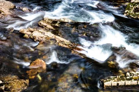 Long Exposure of Water Flowing through rocks in the river Stock Photos