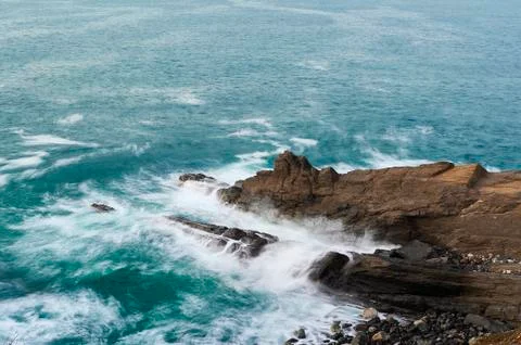 Long exposure of waves breaking over the rocks Stock Photos
